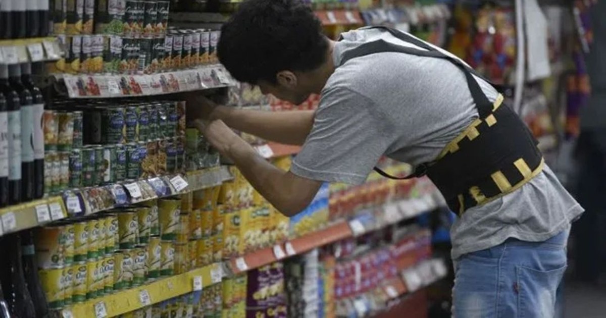Empleado de comercio revisa el recibo de sueldo con la nueva base salarial