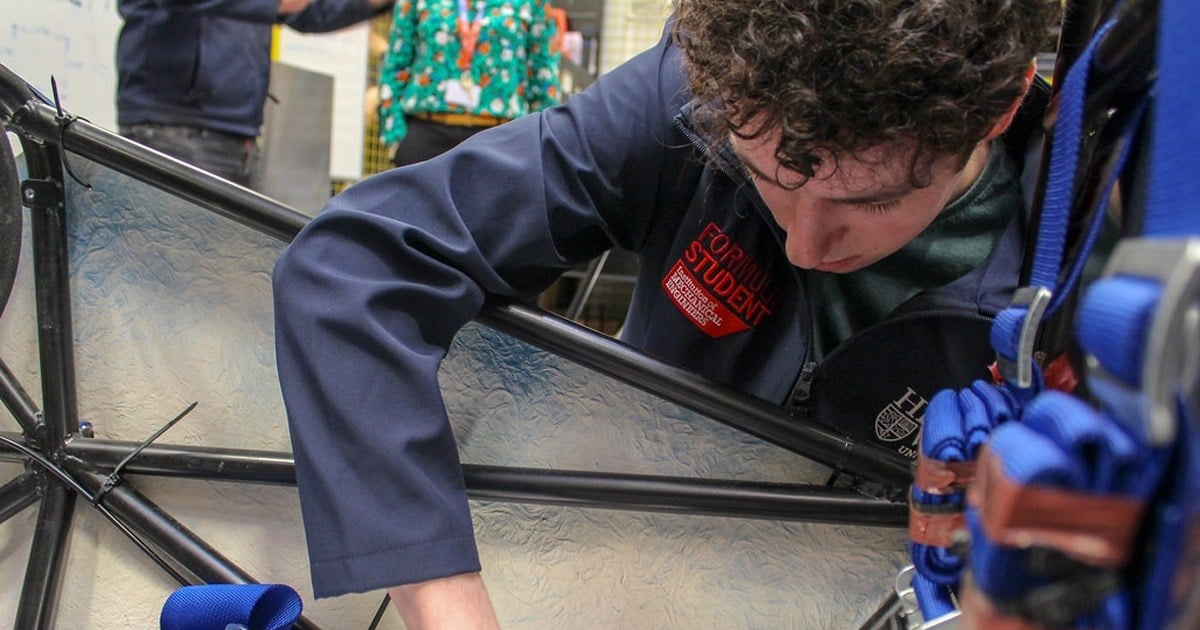 Estudiantes ajustan el chasis y el motor de un auto eléctrico en el taller de una escuela técnica neuquina