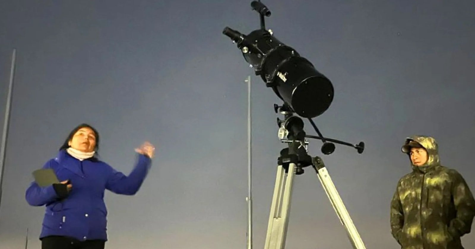 Grupo reducido observa el cielo nocturno con telescopio en un paisaje neuquino