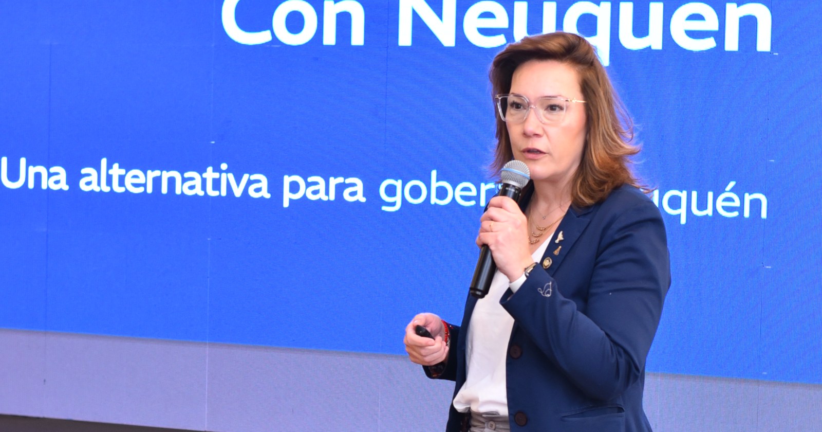Brenda Buchiniz, micrófono en mano, durante la presentación del plan de gobierno de Cumplir en Neuquén