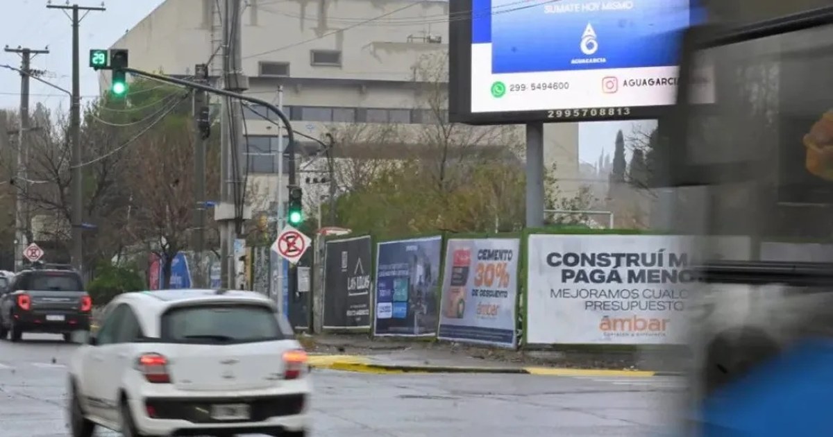 Cartel digital publicitario iluminado de noche en un corredor comercial de Neuquén