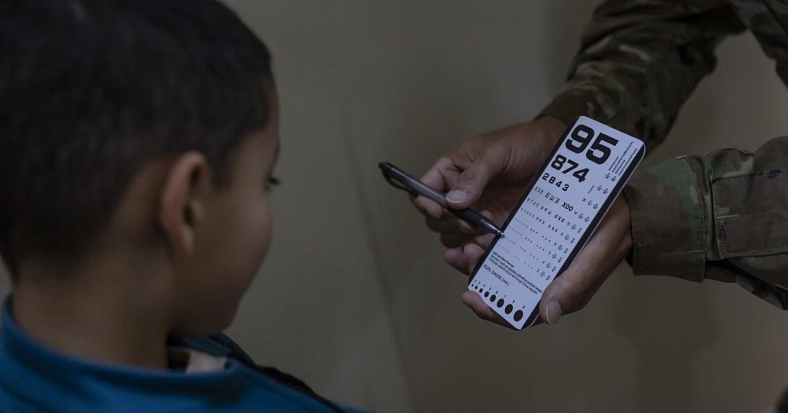 Profesional de oftalmología realiza un examen de la vista a un niño en un consultorio