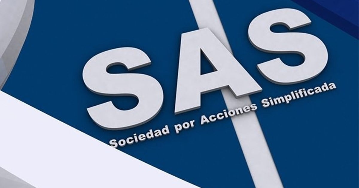 Persona firma documentación societaria ante un escribano, con sellos y carpeta sobre el escritorio