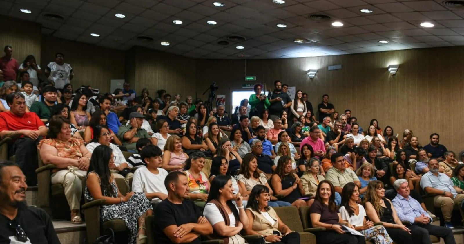 Público sentado en las butacas de un auditorio con paredes de madera y escaleras laterales, durante un acto del Consejo Provincial de Educación