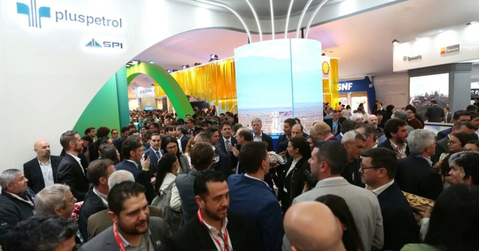 Multitud de visitantes con credenciales recorre los pasillos de la Expo Oil & Gas frente al stand de Pluspetrol