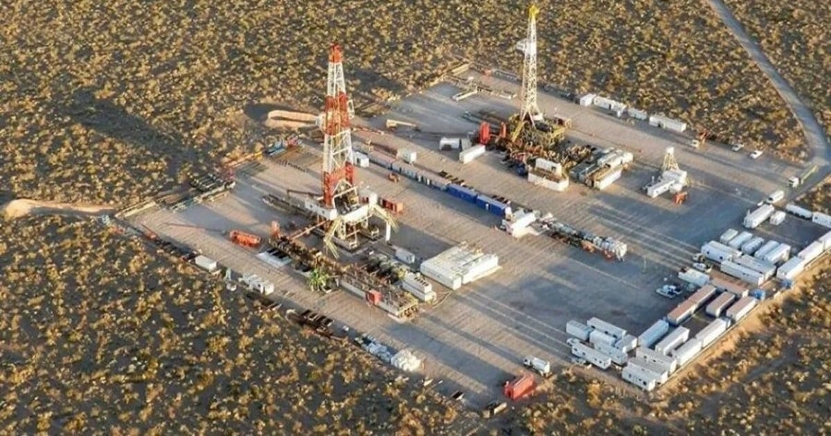 Vista aérea de una locación petrolera con dos torres de perforación, tráileres y equipos en medio de la meseta neuquina