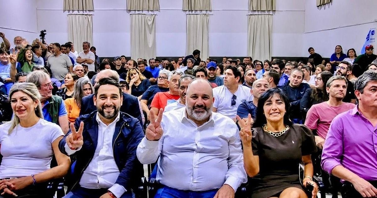 Dirigentes y militantes hacen la V con los dedos en un salón colmado durante un acto del PJ de Neuquén