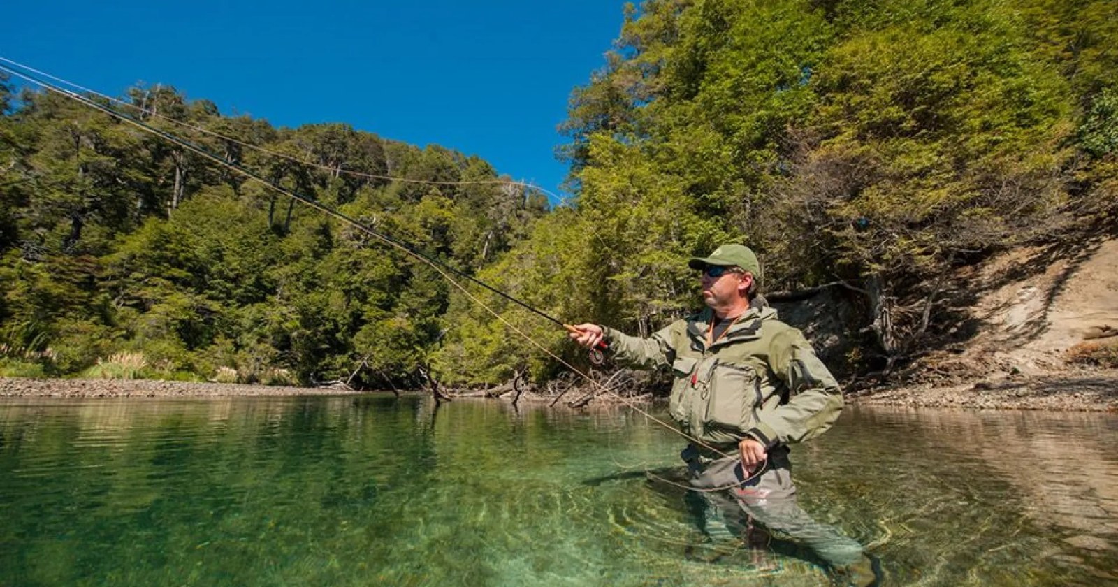 Costa del río Chimehuín con carpas sobre la ribera y pescadores en el agua