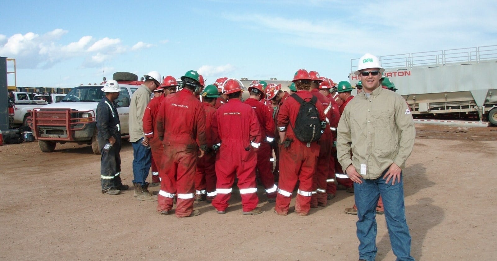 Trabajadores de servicios petroleros con mamelucos rojos en una base de Añelo